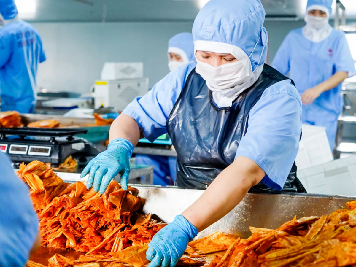 工作人员正在挑选麻辣豆皮